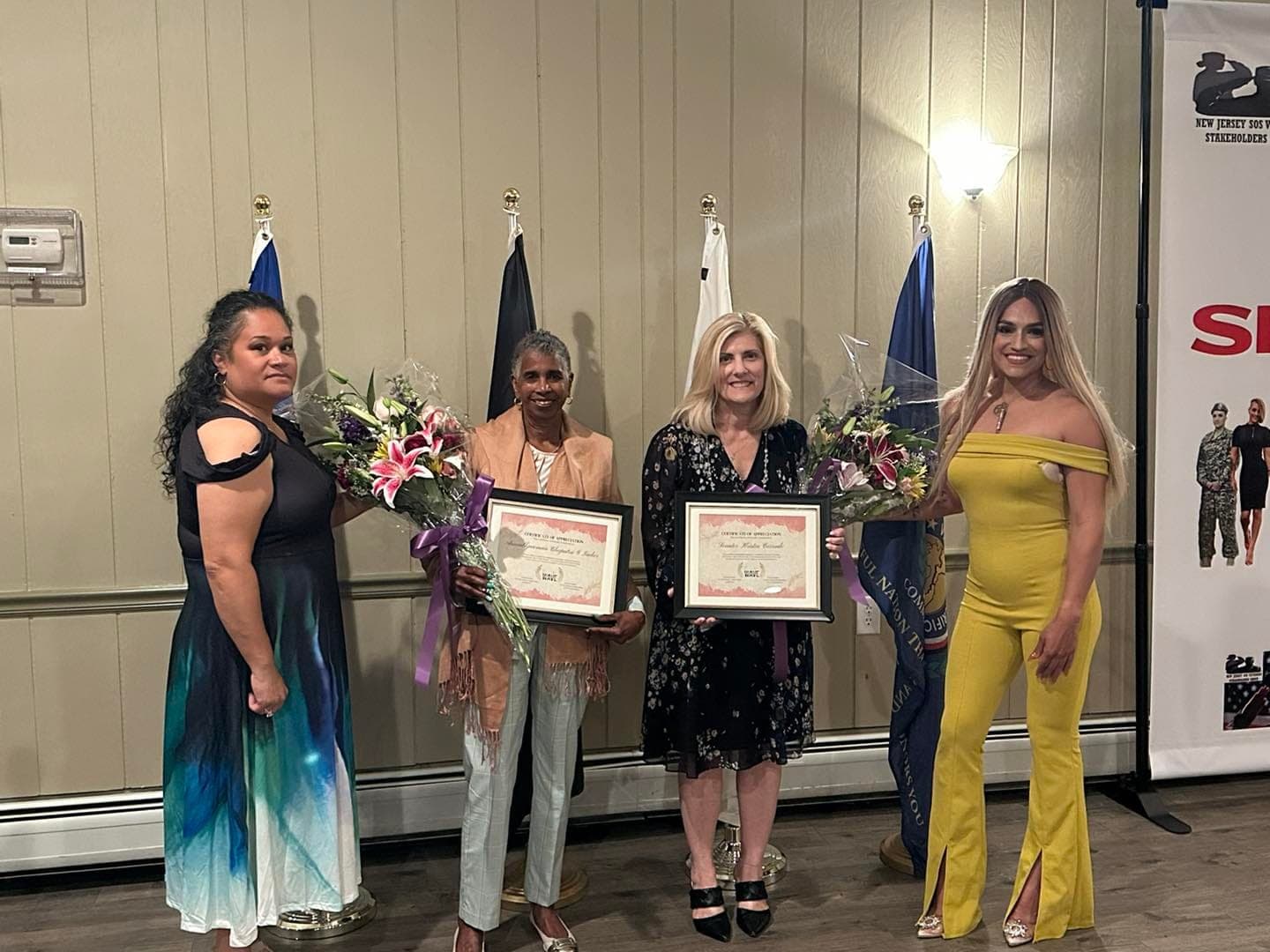 Honorees holding certificates and flowers alongside event organizers