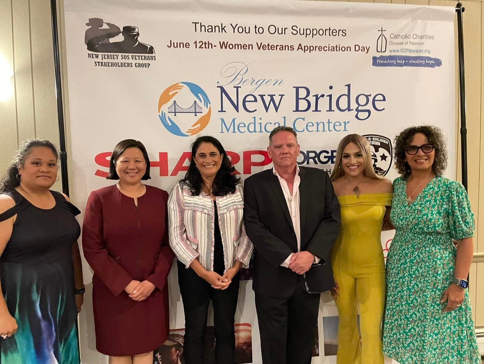 Partners and supporters gathered in front of the event banner