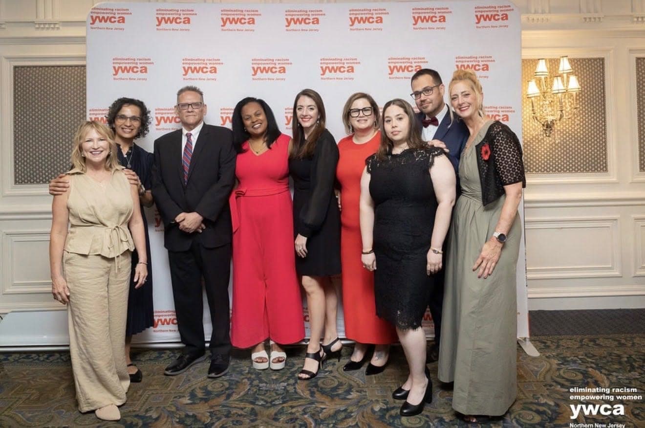 Group of honorees and supporters at the event banner