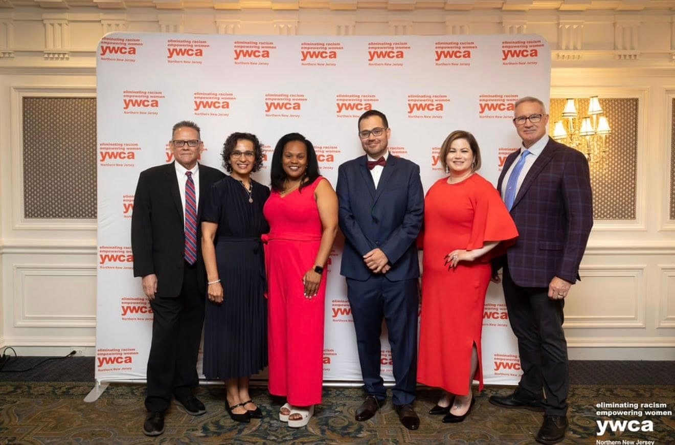 Group of honorees and organizers at the event banner