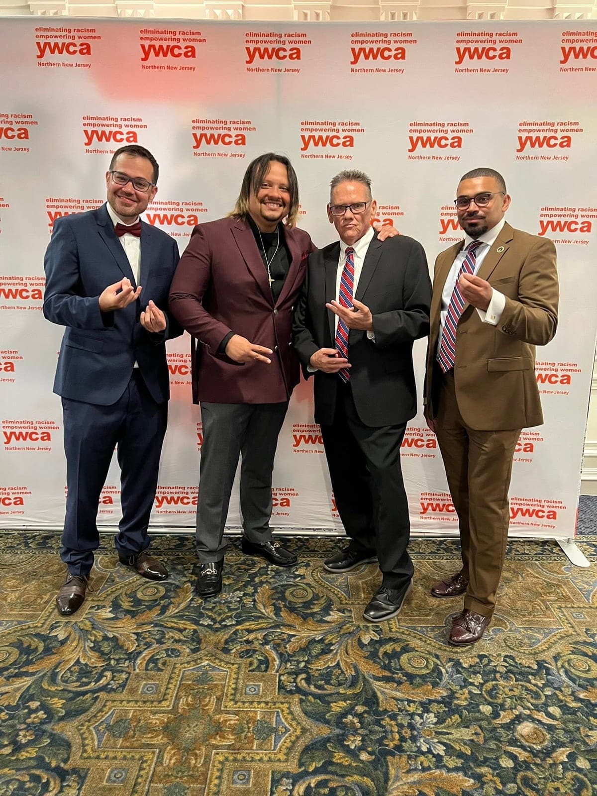 Four guests posing at the event banner